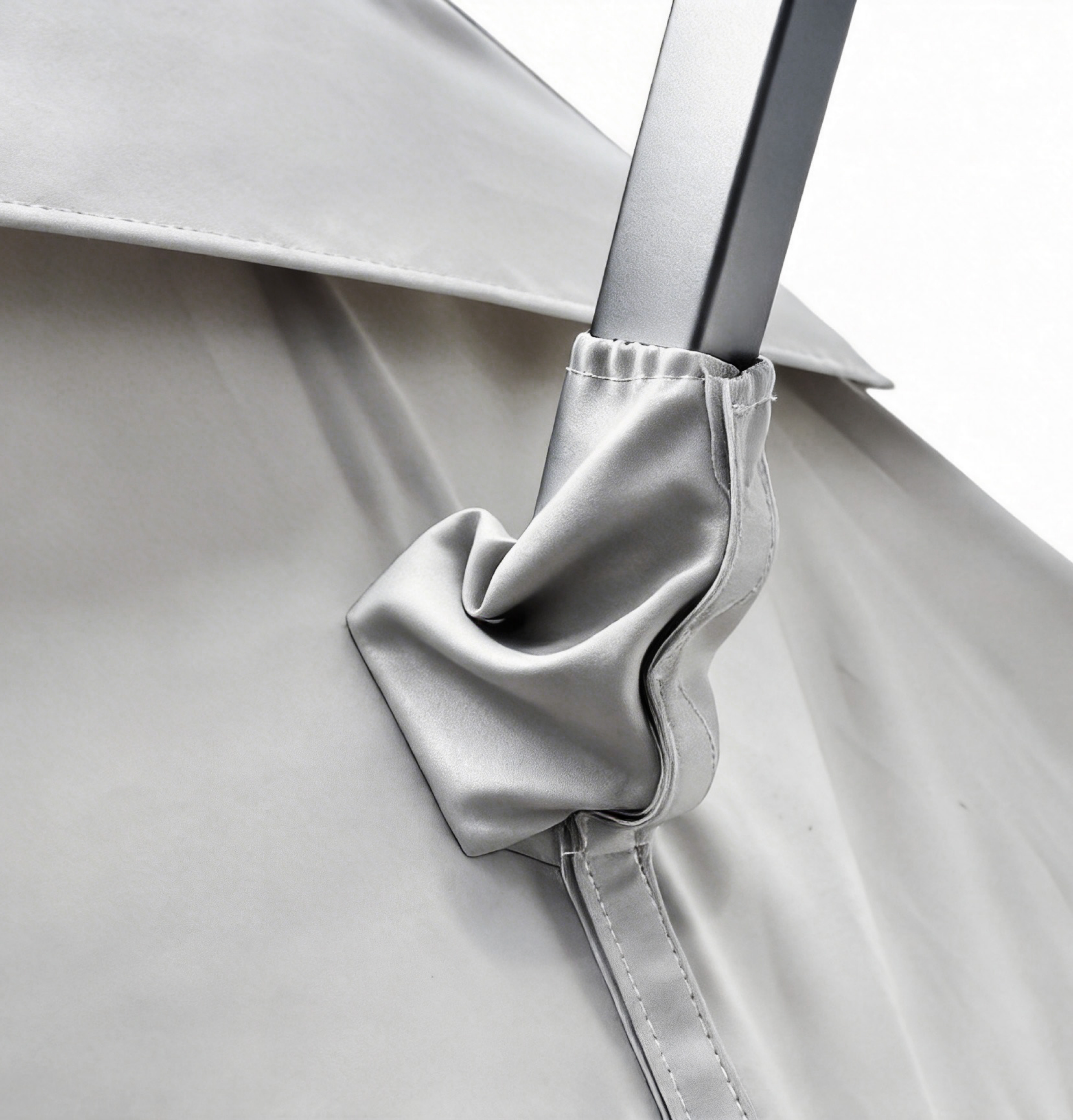 Silbernes Stoffband um einen silbernen Metallstab gebunden, Nahaufnahme.