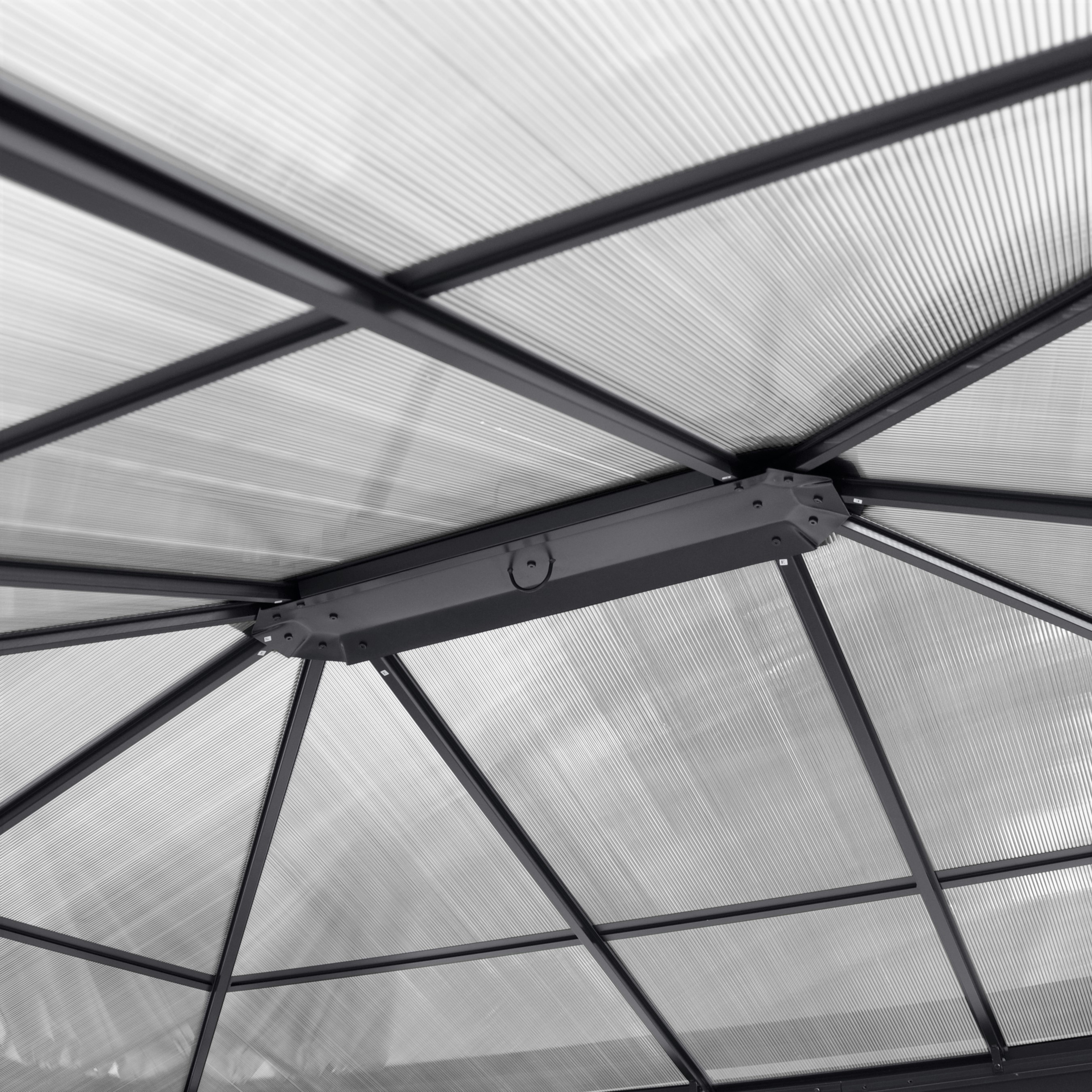 Metallrahmen-Dachkonstruktion mit transparenten Wellplatten aus Polycarbonat von unten sichtbar.