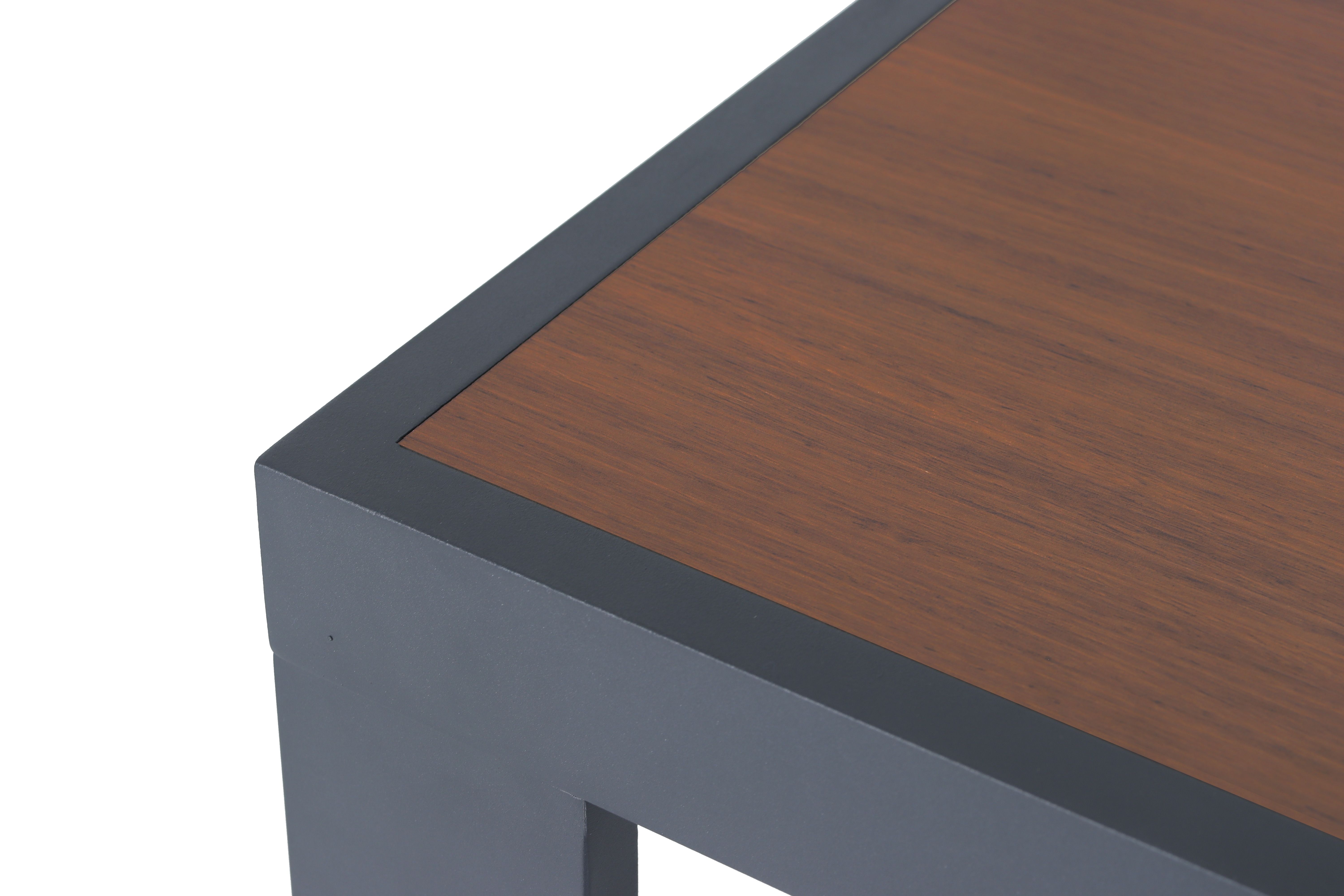 Ecke eines Tischs mit Holzplatte und Metallrahmen in Nahaufnahme.