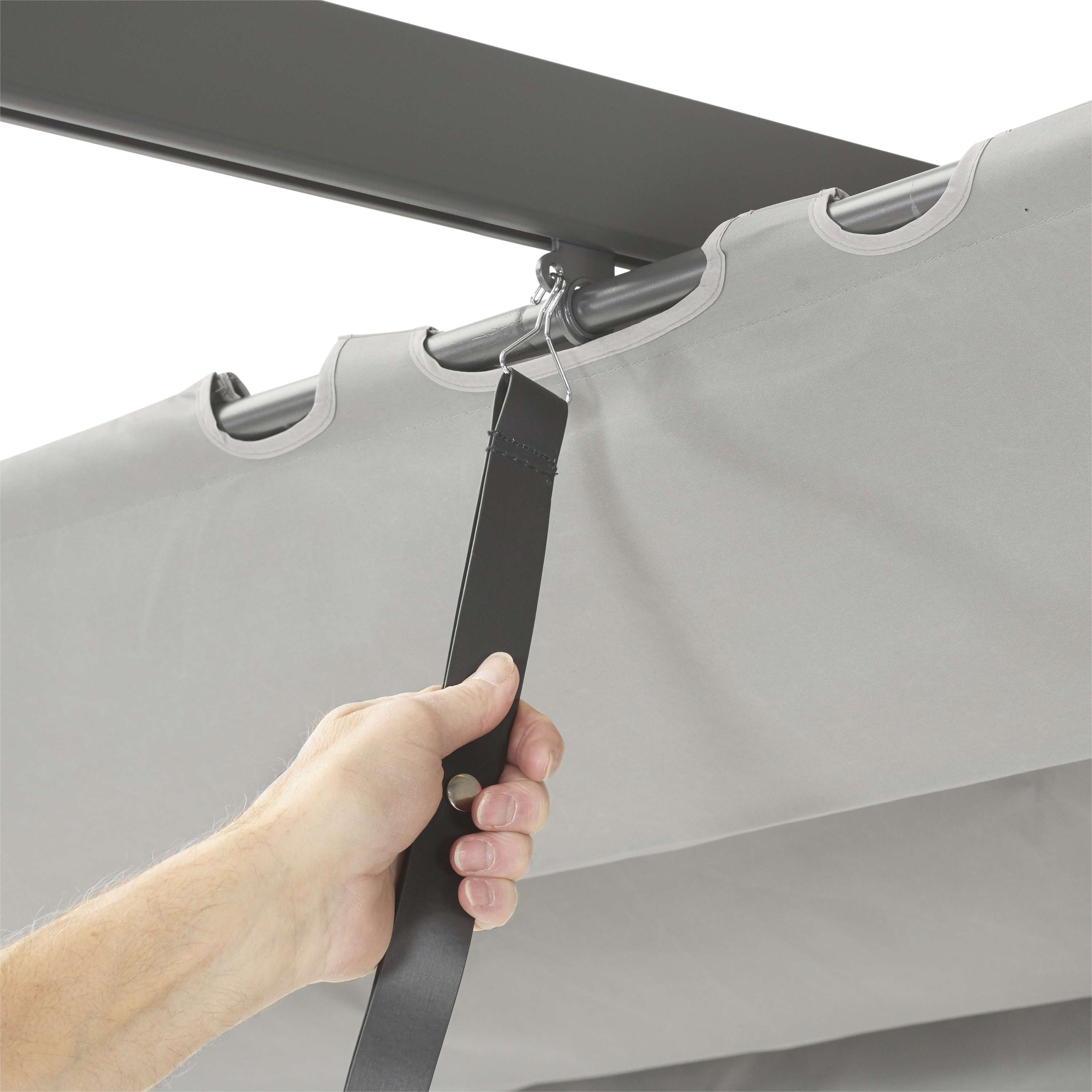 Hand zieht an schwarzem Gurt, der an grauem Stoffdach befestigt ist.