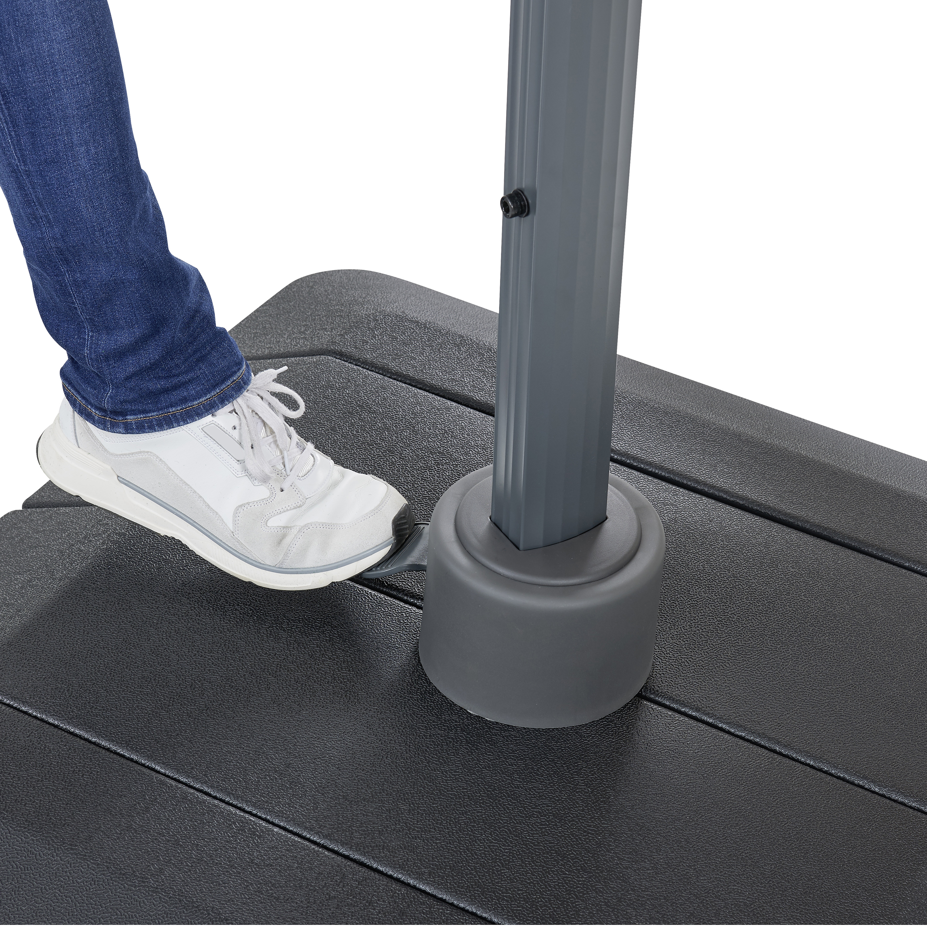 Fuß in Turnschuh tritt auf Pedal an der Basis eines Schirmständers.
