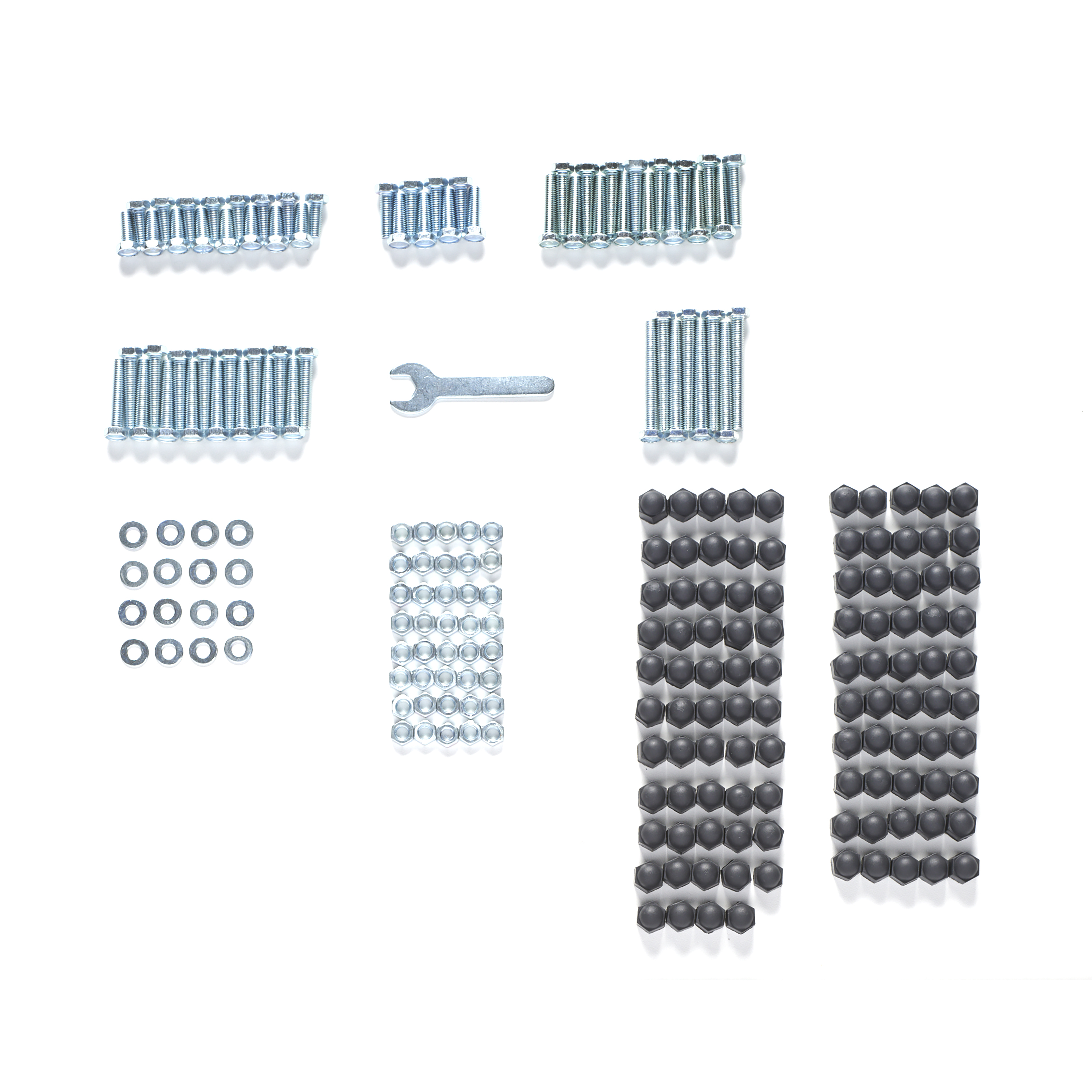 Schrauben, Muttern, Unterlegscheiben, zwei Reihen Sechskantabdeckungen und ein Schraubenschlüssel auf weißem Hintergrund angeordnet.